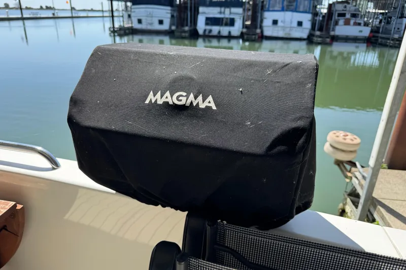Slide: The Image of Black Magma grill cover on 2006 Carver 46 Voyager yacht, docked by calm waters. - 24