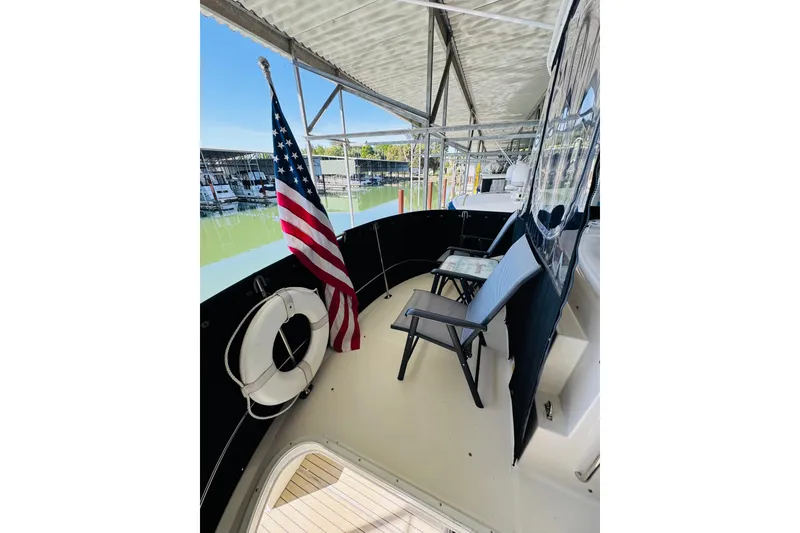 Slide: The Image of 2006 Carver 46 Voyager yacht deck with chairs, American flag, and life preserver. - 28