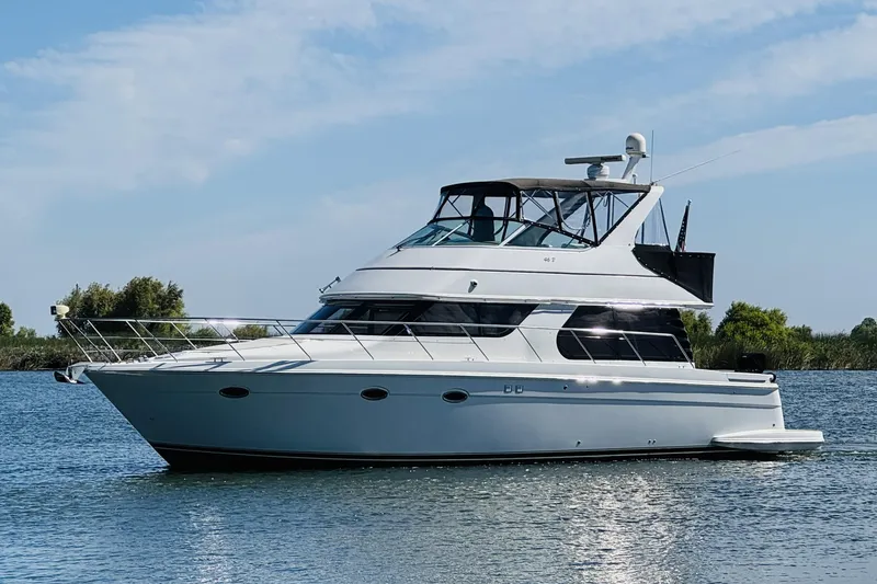 Slide: The Image of 2006 Carver 46 Voyager yacht on calm water, clear sky background. - 3