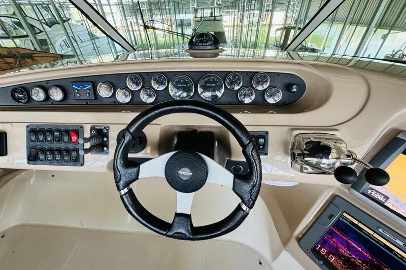 Slide: The Image of 2006 Carver 46 Voyager helm with steering wheel, gauges, and navigation controls. - 39
