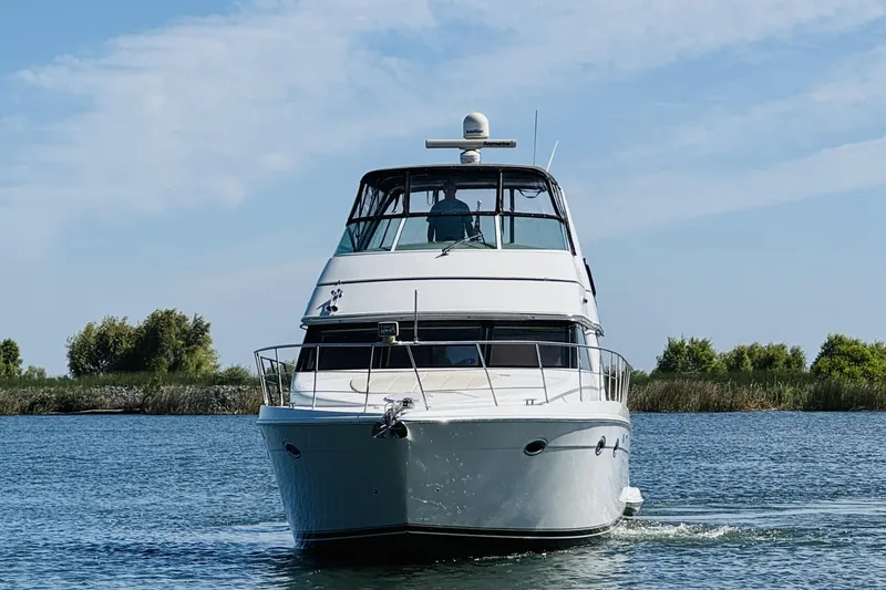 Slide: The Image of 2006 Carver 46 Voyager yacht cruising on a serene waterway. - 5