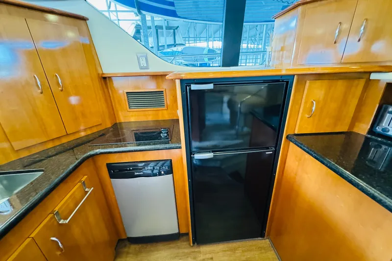 Slide: The Image of Luxurious 2006 Carver 46 Voyager yacht kitchen with wood cabinetry and modern appliances. - 63