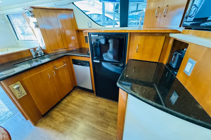 Slide: The Image of Luxurious 2006 Carver 46 Voyager yacht kitchen with wood cabinetry and modern appliances. - 68