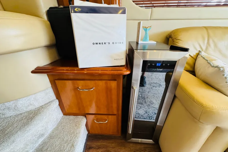Slide: The Image of Owner's guide on wooden cabinet beside mini fridge in Carver 46 Voyager yacht. - 72