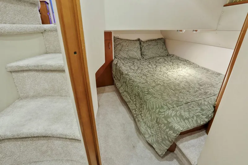 Slide: The Image of Cozy bedroom in 2006 Carver 46 Voyager yacht with patterned bedding and carpeted stairs. - 77