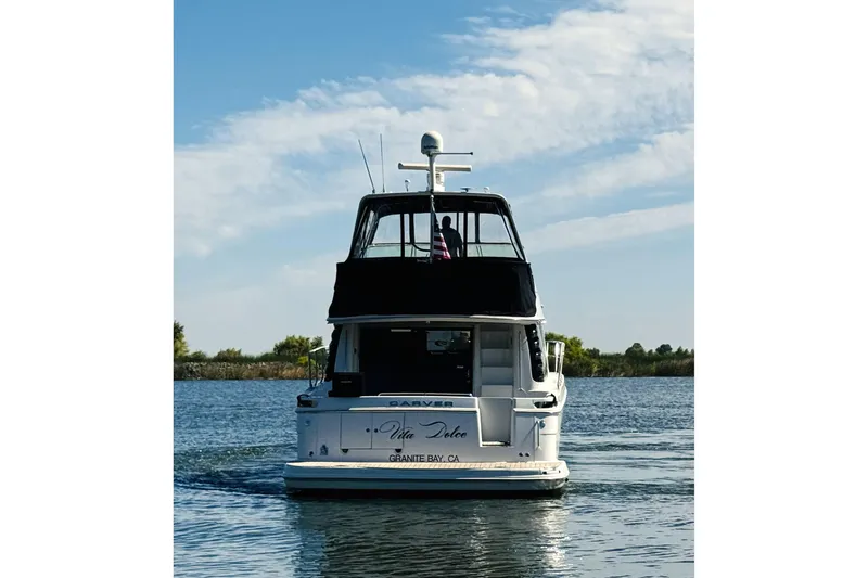Slide: The Image of 2006 Carver 46 Voyager yacht cruising on a calm waterway under a blue sky. - 8