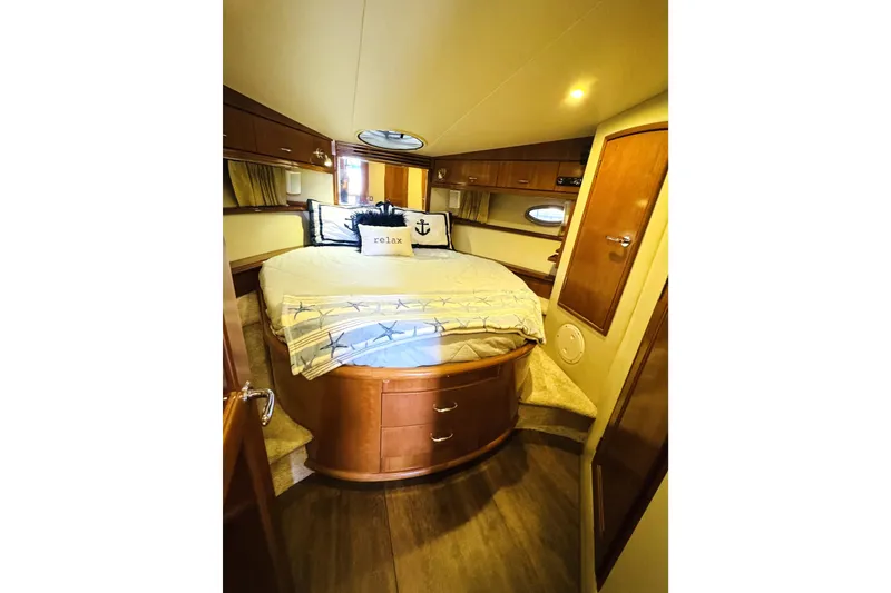 Slide: The Image of Luxurious 2006 Carver 46 Voyager yacht bedroom with cozy bedding and elegant wood finishes. - 82