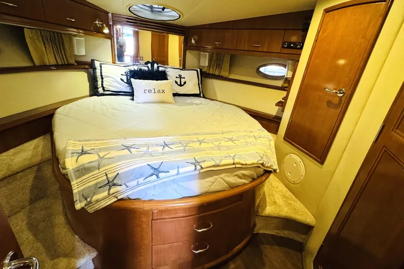 Slide: The Image of Luxurious 2006 Carver 46 Voyager yacht bedroom with cozy bedding and nautical decor. - 83