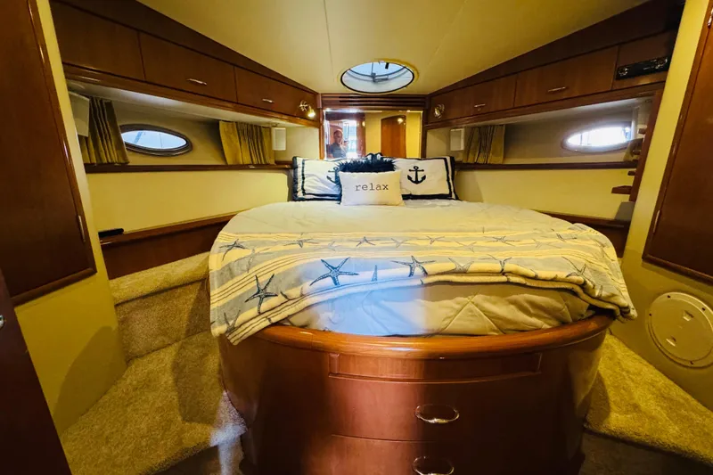 Slide: The Image of Luxurious 2006 Carver 46 Voyager yacht bedroom with cozy bedding and elegant wood finishes. - 85