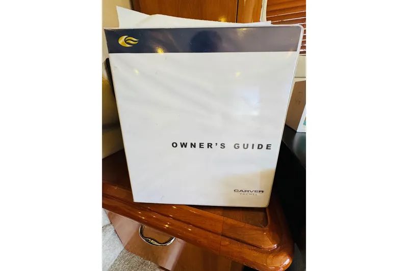 Slide: The Image of Owner's guide for 2006 Carver 46 Voyager yacht on wooden table. - 87
