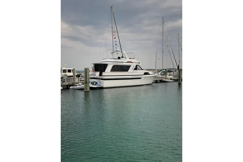 Slide: The Image of 1988 Chris-Craft 501 Motor Yacht docked in a marina under cloudy skies. - 2