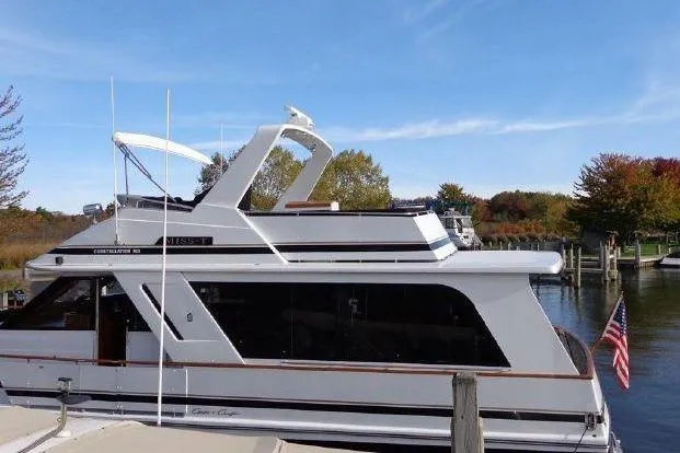 Slide: The Image of 1988 Chris-Craft 501 Motor Yacht docked, featuring sleek design and American flag. - 4