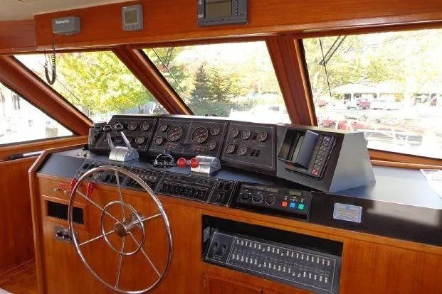 Slide: The Image of 1988 Chris-Craft 501 Motor Yacht helm with steering wheel and control panel. - 5