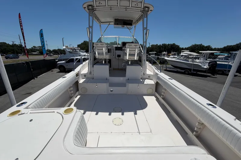 Slide: The Image of 1994 Grady-White Sailfish 272 boat interior, spacious deck, and seating area under clear sky. - 14