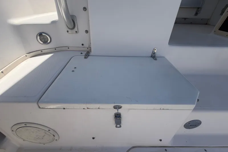 Slide: The Image of 1994 Grady-White Sailfish 272 boat storage compartment with latch and seating area. - 19