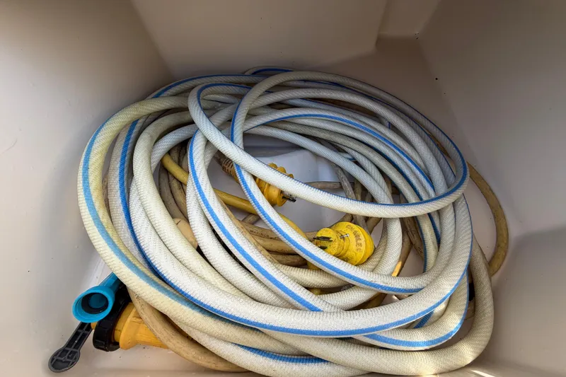 Slide: The Image of Coiled hoses and connectors in a Grady-White Sailfish 272 storage compartment. - 24