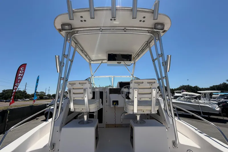 Slide: The Image of 1994 Grady-White Sailfish 272 boat interior with dual helm seats and T-top under clear sky. - 25