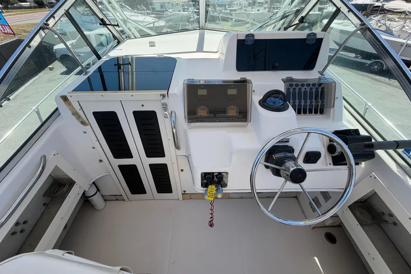 Slide: The Image of 1994 Grady-White Sailfish 272 boat cockpit with steering wheel and control panel. - 27