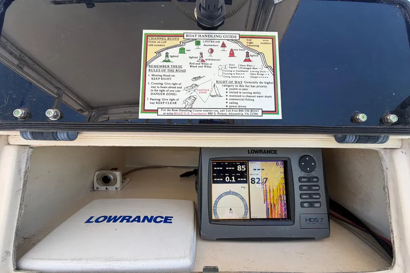 Slide: The Image of 1994 Grady-White Sailfish 272 boat dashboard with Lowrance navigation system and handling guide. - 30