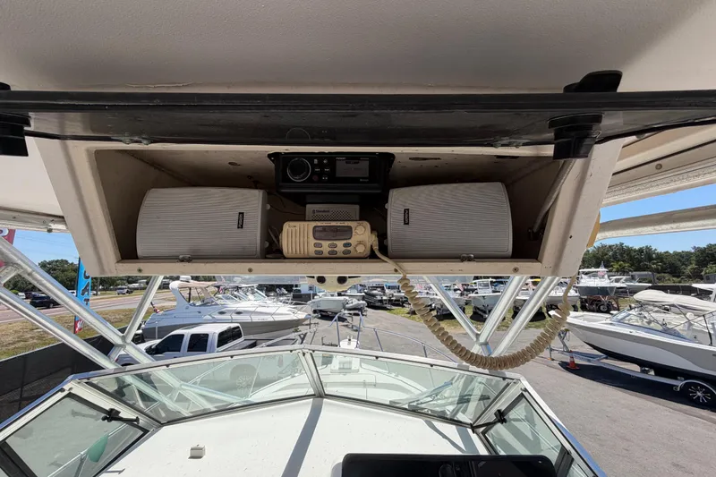 Slide: The Image of 1994 Grady-White Sailfish 272 boat dashboard with radio and speakers, marina background. - 35