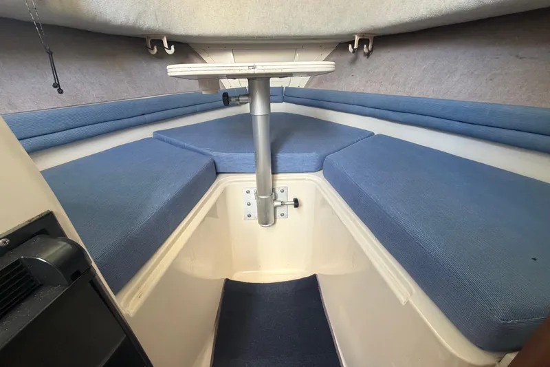 Slide: The Image of 1994 Grady-White Sailfish 272 cabin interior with blue cushions and compact table. - 48