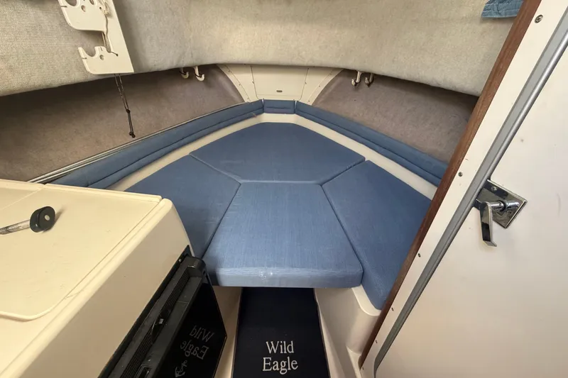 Slide: The Image of 1994 Grady-White Sailfish 272 cabin interior with blue cushions and compact design. - 49