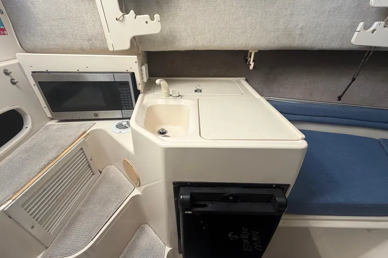 Slide: The Image of 1994 Grady-White Sailfish 272 cabin interior with sink, microwave, and seating area. - 53