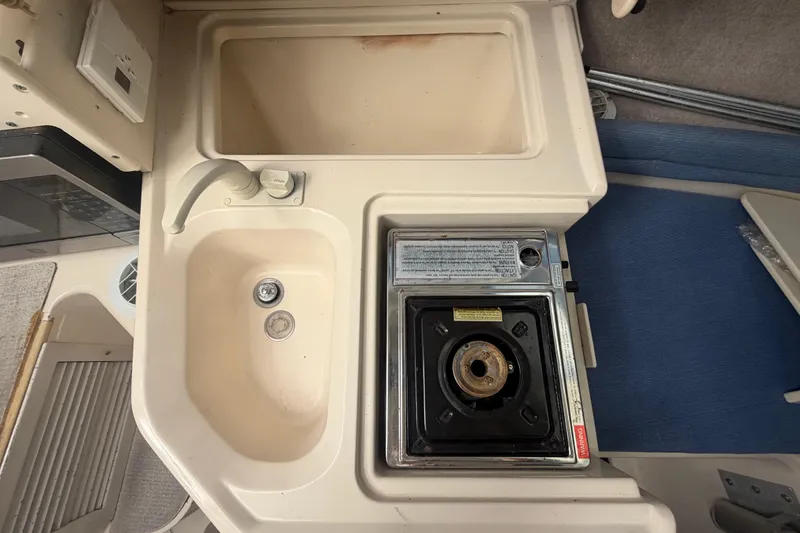 Slide: The Image of 1994 Grady-White Sailfish 272 boat kitchenette with sink and stove. - 55