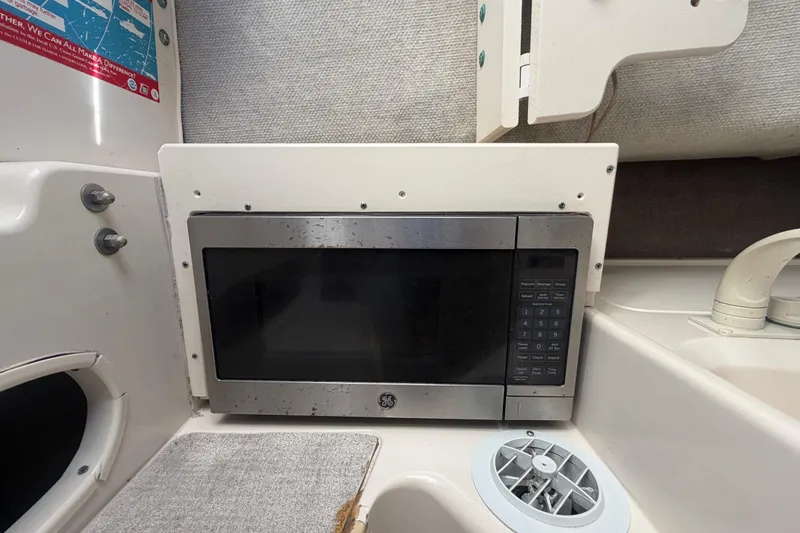 Slide: The Image of Microwave in 1994 Grady-White Sailfish 272 boat interior, featuring compact kitchen setup. - 59