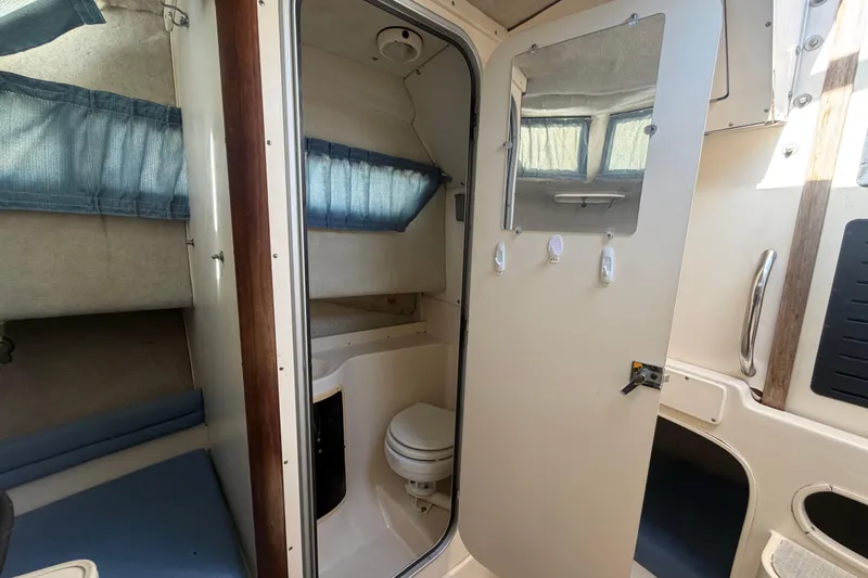 Slide: The Image of 1994 Grady-White Sailfish 272 cabin interior with bathroom and sleeping area. - 63