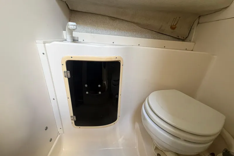 Slide: The Image of 1994 Grady-White Sailfish 272 boat bathroom with toilet and storage compartment. - 65