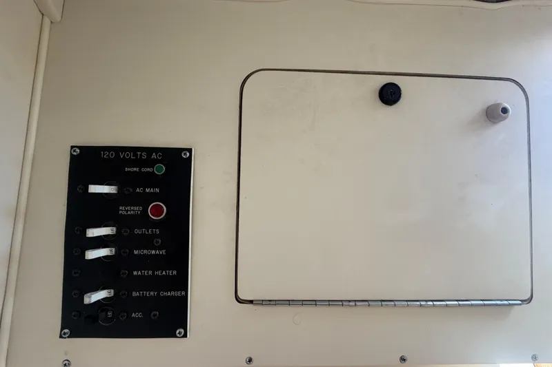 Slide: The Image of Electrical panel of a 1994 Grady-White Sailfish 272 boat, featuring AC controls. - 68