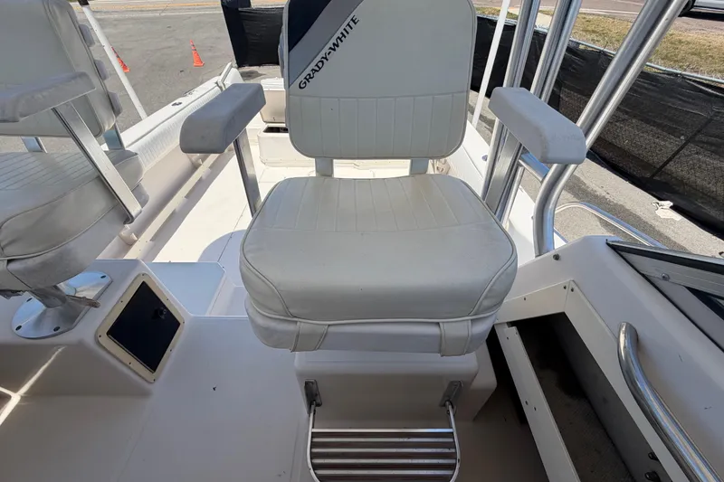 Slide: The Image of 1994 Grady-White Sailfish 272 boat seat with white upholstery and armrests. - 73