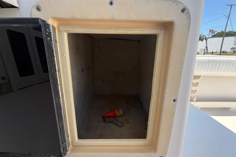 Slide: The Image of Storage compartment on a 1994 Grady-White Sailfish 272 boat, containing a small tool. - 79