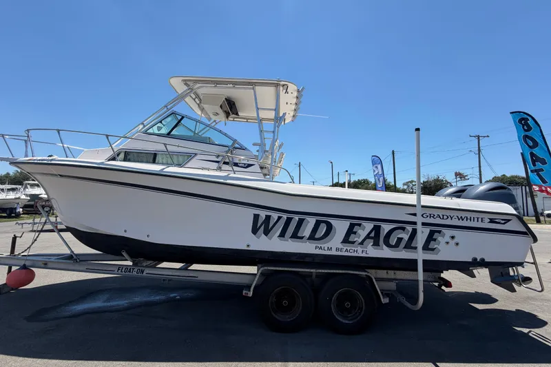 Slide: The Image of 1994 Grady-White Sailfish 272 boat on trailer, labeled "Wild Eagle," in sunny outdoor setting. - 8
