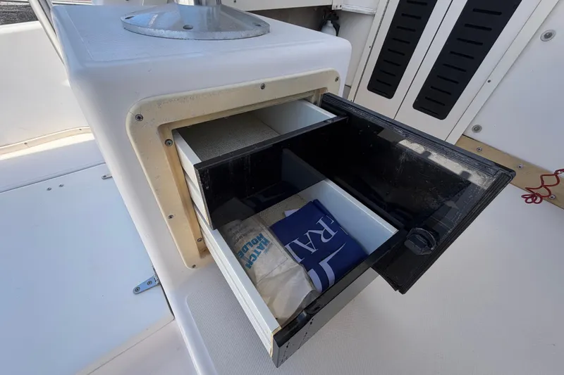 Slide: The Image of Storage compartment on a 1994 Grady-White Sailfish 272 boat, featuring open drawers. - 81