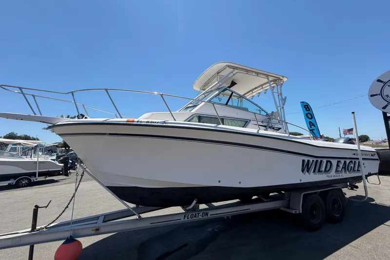 Slide: The Image of 1994 Grady-White Sailfish 272 boat on trailer, labeled "Wild Eagle," under clear blue sky. - 9