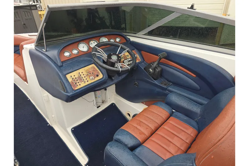 Slide: The Image of Interior of a 2003 Cobalt 262 boat with blue and brown seating. - 10