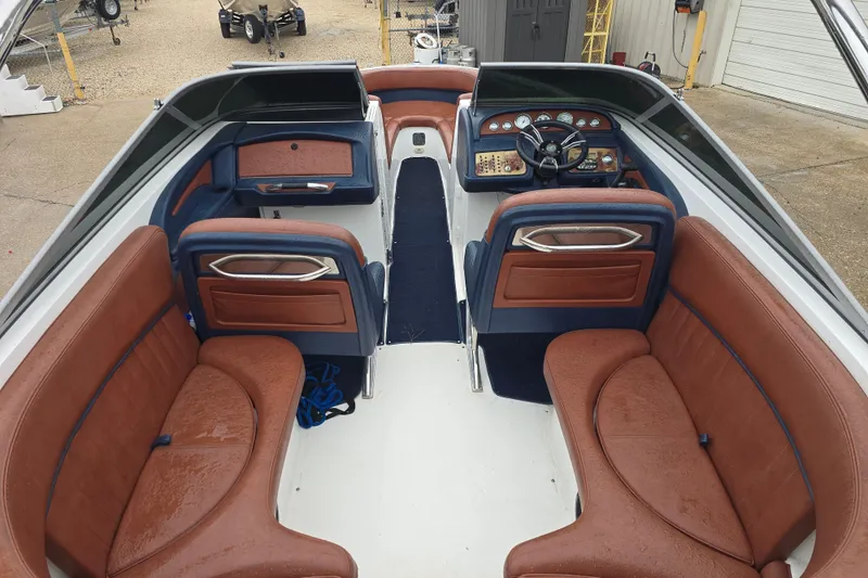Slide: The Image of 2003 Cobalt 262 boat interior with brown leather seating and modern dashboard. - 13
