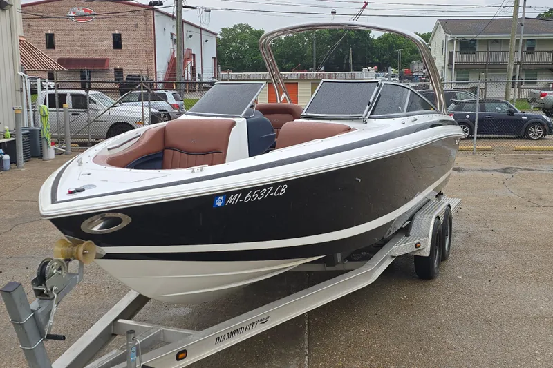 Slide: The Image of 2003 Cobalt 262 boat on trailer, parked outdoors with brown seating. - 6