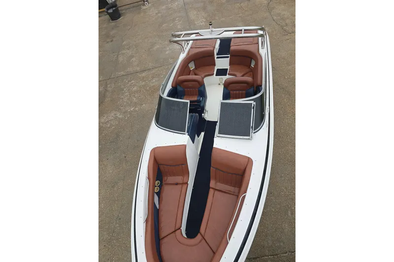 Slide: The Image of 2003 Cobalt 262 boat with brown seating and sleek design on concrete surface. - 8