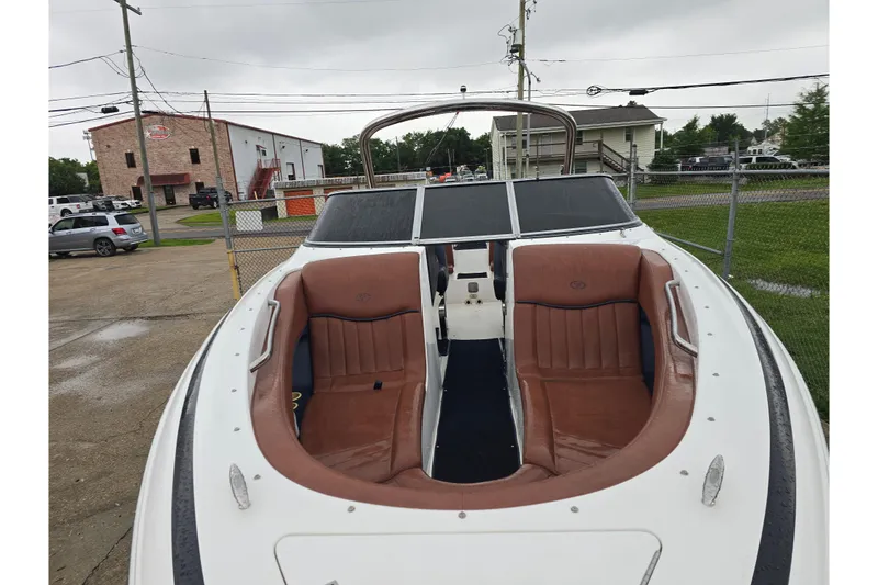 Slide: The Image of 2003 Cobalt 262 boat with brown seating, parked outdoors on a cloudy day. - 9