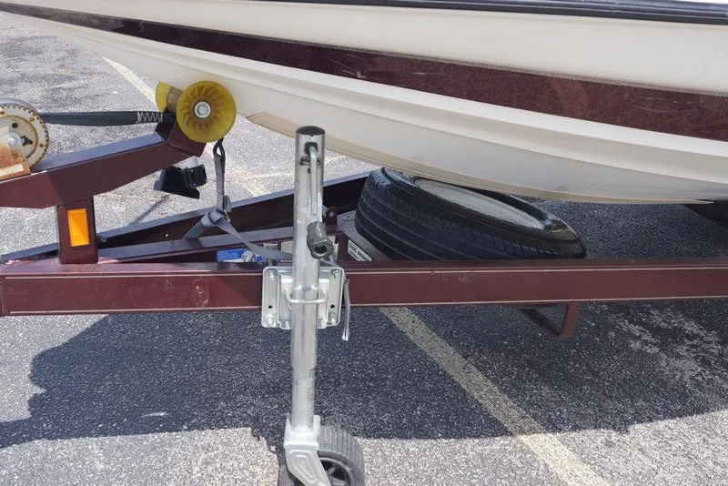 Slide: The Image of Trailer with 2004 Triton Tr-196 DC boat, featuring a spare tire and winch system. - 1