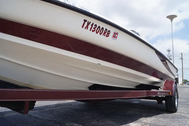 Slide: The Image of 2004 Triton Tr-196 DC boat on trailer, side view with registration number visible. - 12