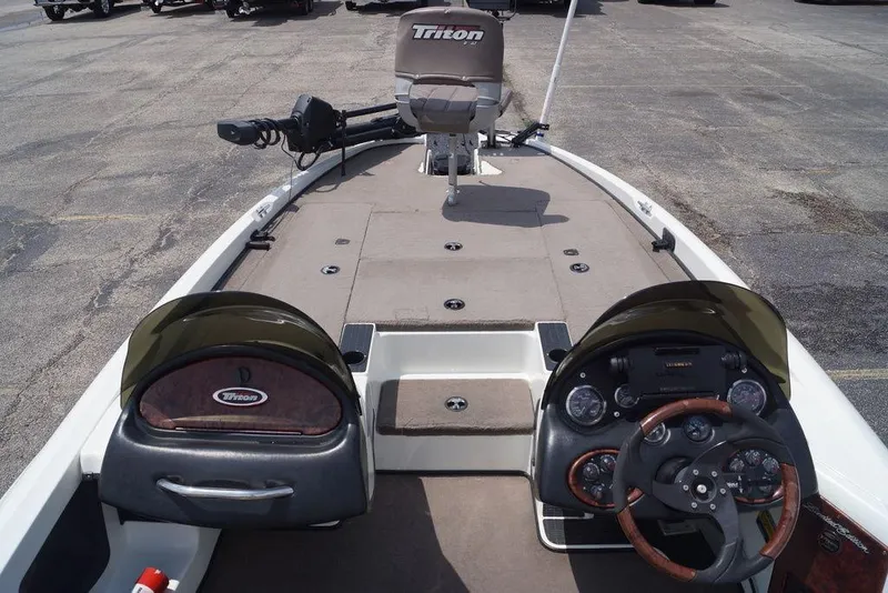 Slide: The Image of 2004 Triton Tr-196 DC boat interior with dual consoles and steering wheel on a paved surface. - 16