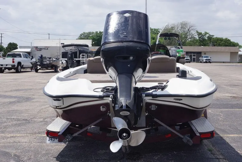 Slide: The Image of 2004 Triton Tr-196 DC boat with outboard motor on trailer in parking lot. - 2
