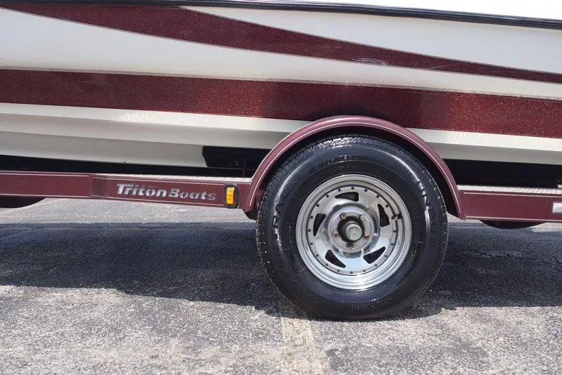 Slide: The Image of 2004 Triton Tr-196 DC boat trailer with maroon detailing and visible tire. - 7