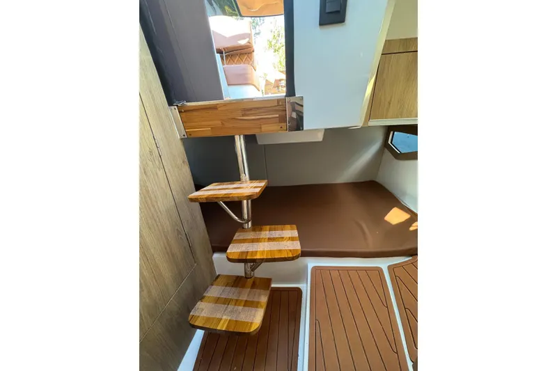 Slide: The Image of Interior of 2025 NX Boats NX290 Exclusive, featuring wooden steps and modern design elements. - 14