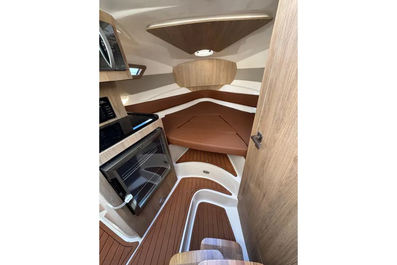 Slide: The Image of Interior of 2025 NX Boats NX290 Exclusive, featuring wood accents and modern amenities. - 15