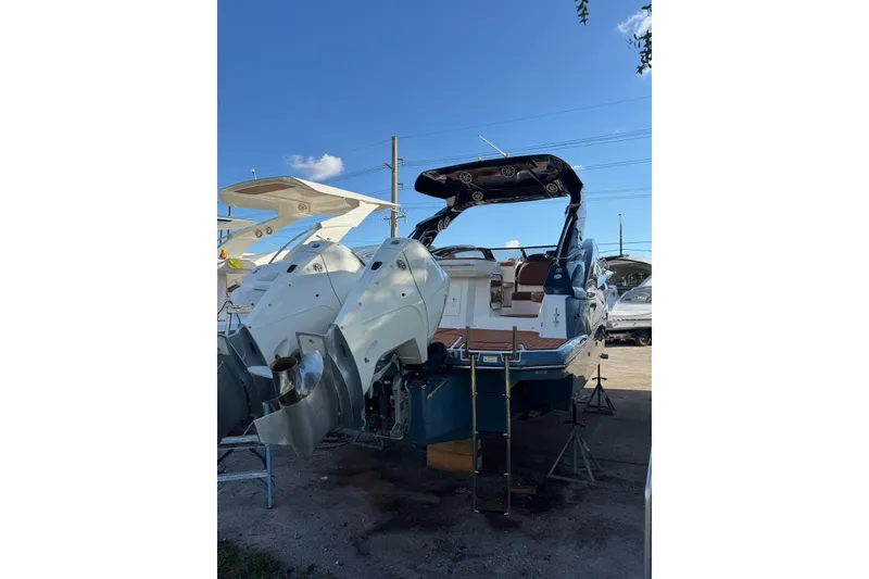 Slide: The Image of 2025 NX Boats NX290 Exclusive with dual engines, docked under clear blue sky. - 24